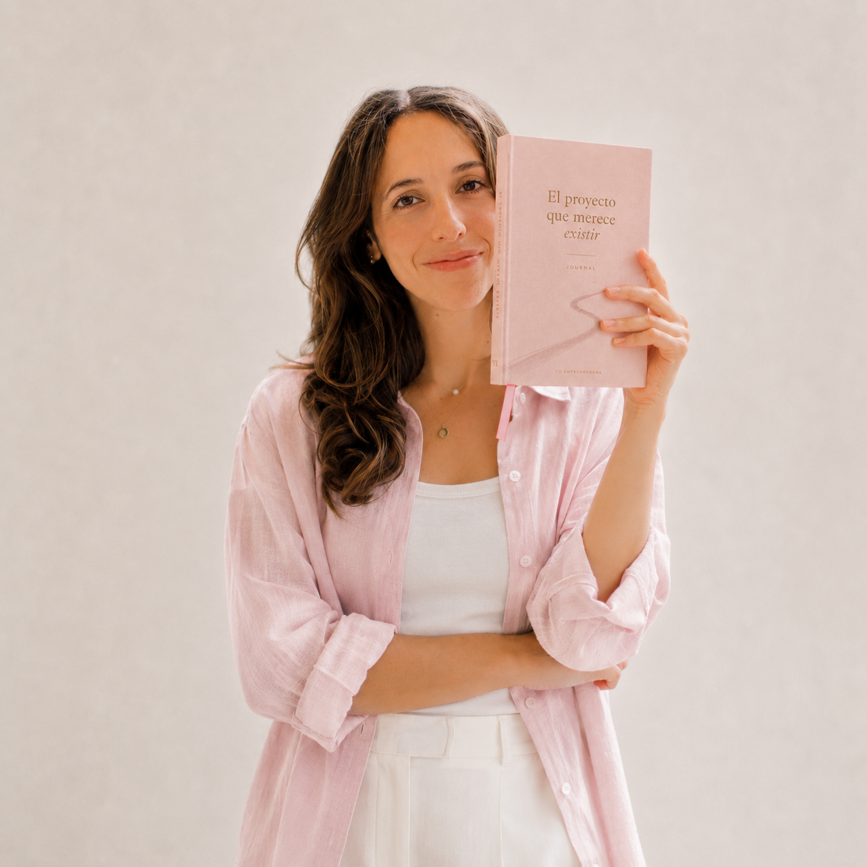 Retrato de la fundadora sosteniendo el journal rosa de El Proyecto Que Merece Existir